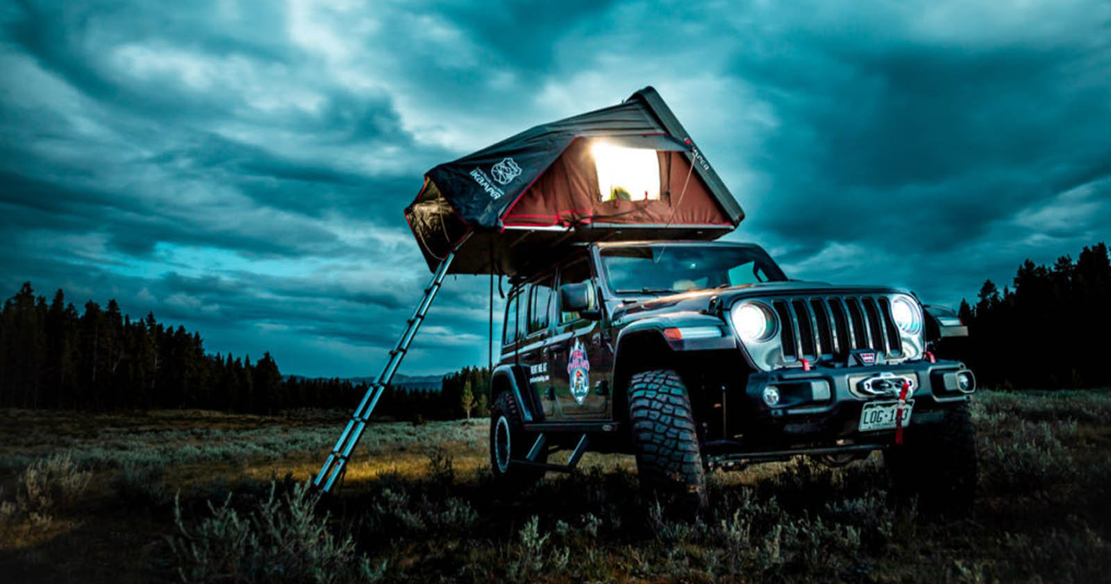 Jeep with a camping tent set up on the roof