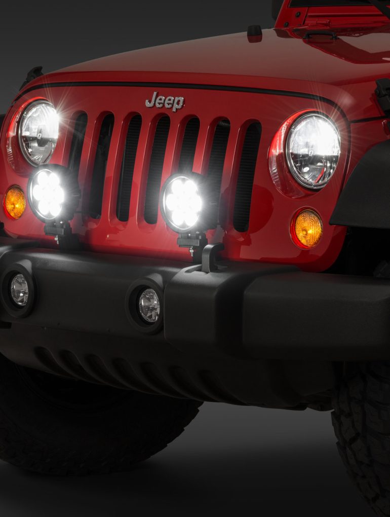 Bright LED headlights on a red Jeep Wrangler