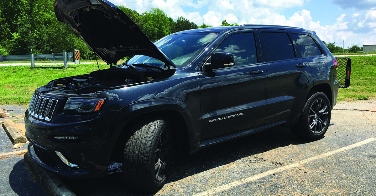 2015 black Jeep grand Cherokee with the hood popped