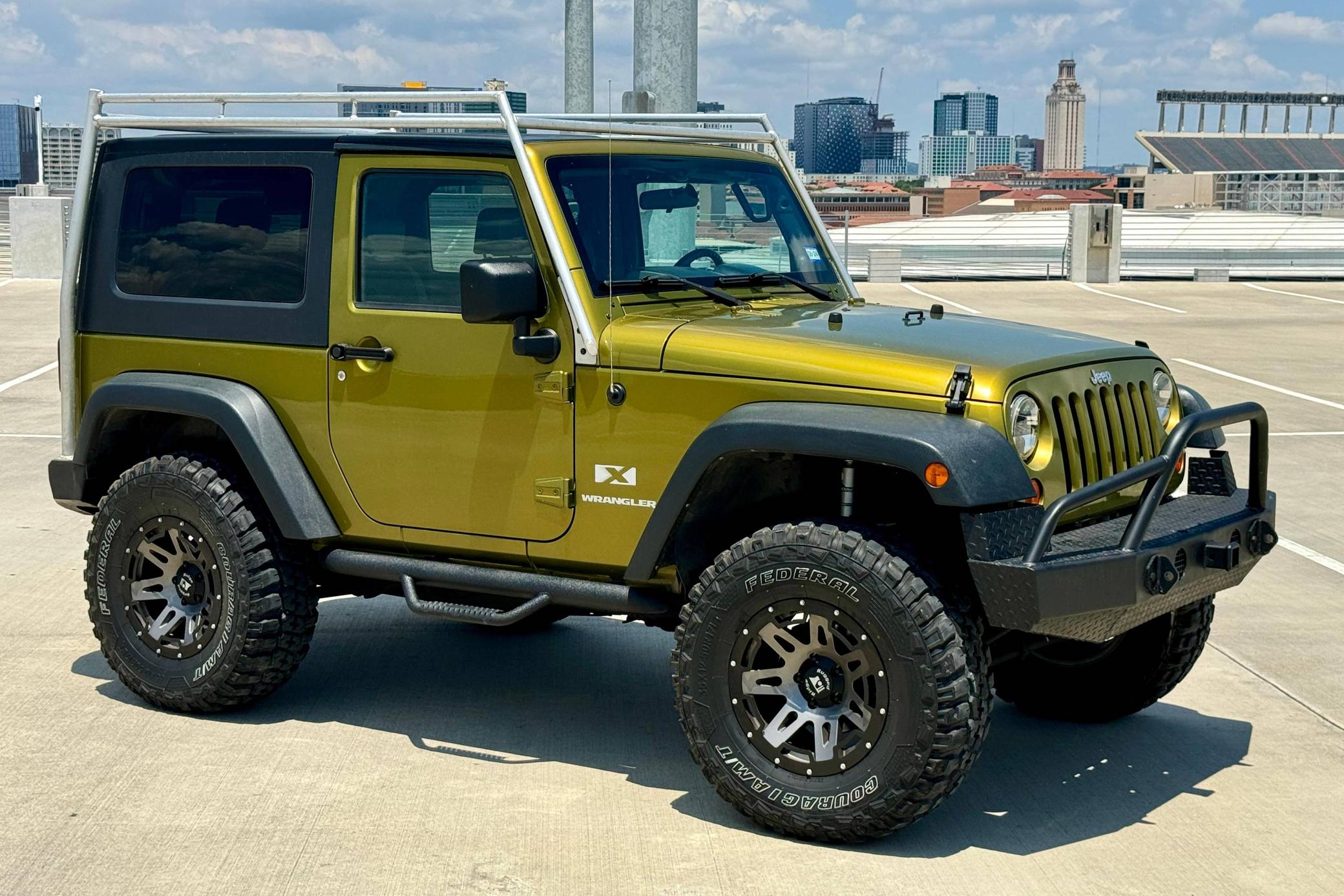 Three-quarter side view of a 2007 green Jeep Wrangler two-dor