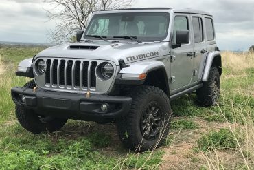 Three-quarter side view of a silver Jeep JL Wrangler Rubicon