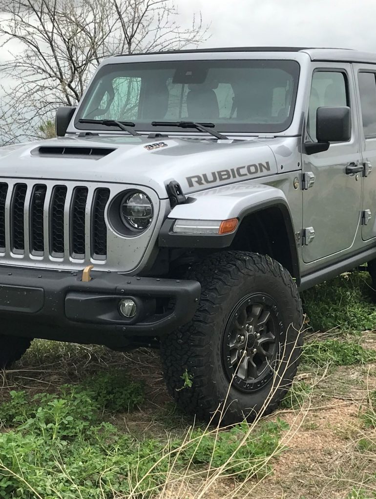 Three-quarter side view of a silver Jeep JL Wrangler Rubicon